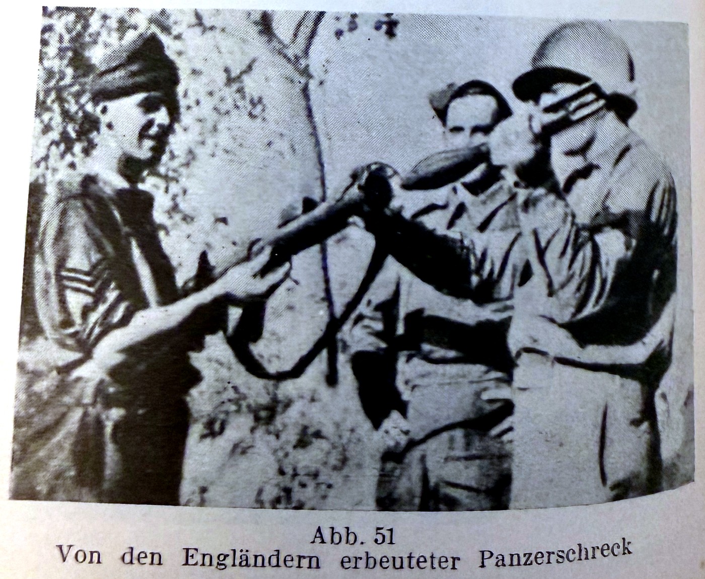 A German Panzerschreck rocket launcher, captured and examined by British soldiers